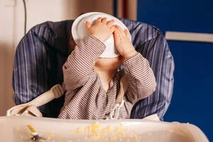 Toddler eating with the face in the plate