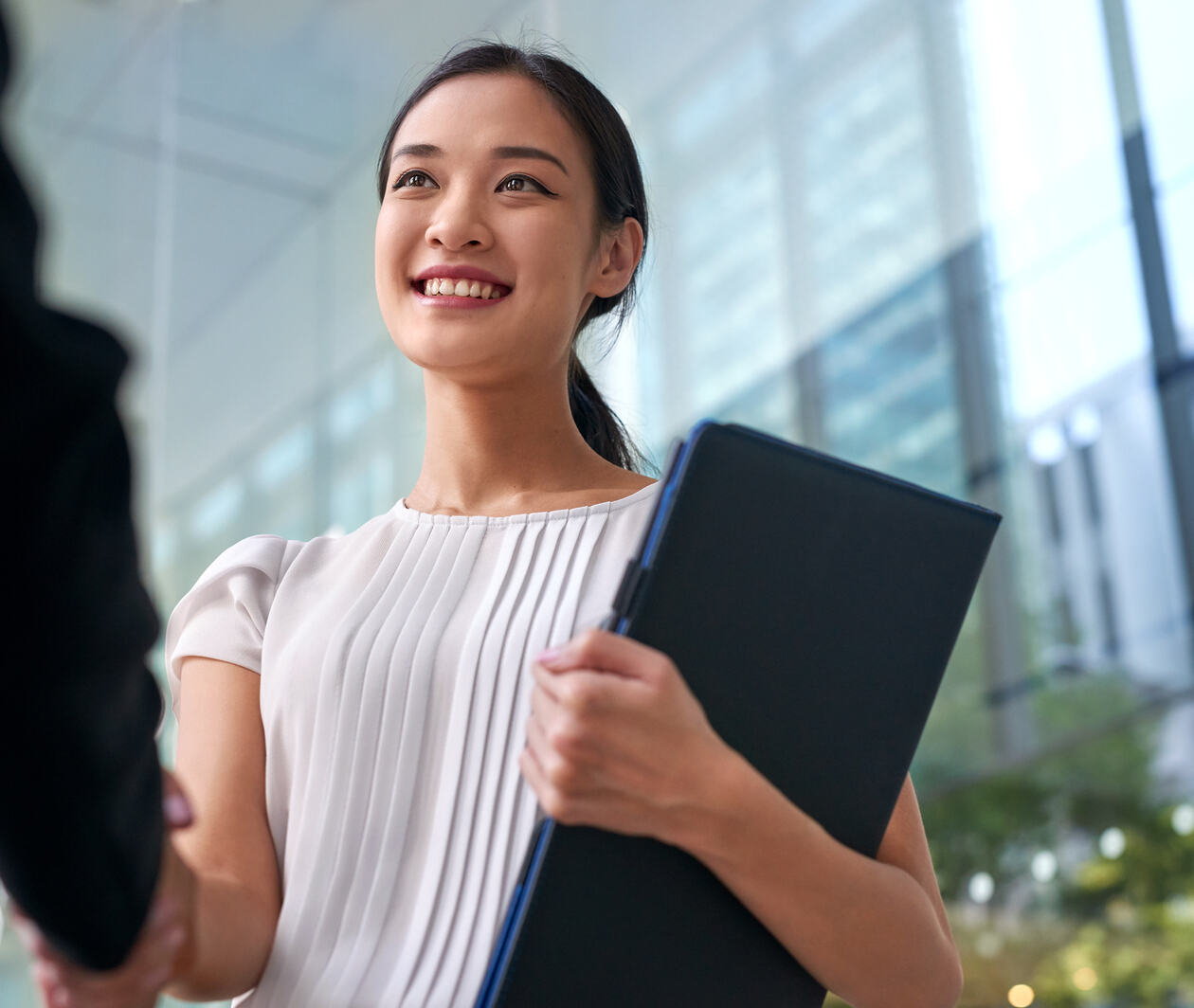 a professional woman walking to a meeting with a tablet