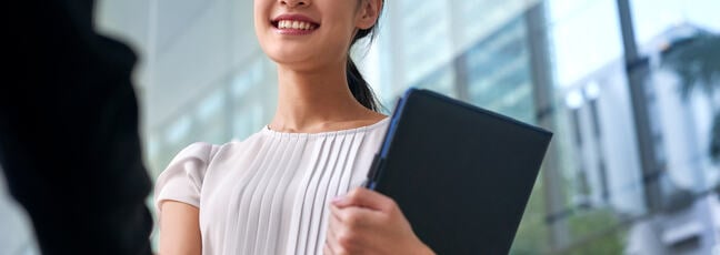 a professional woman walking to a meeting with a tablet