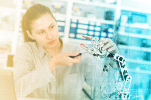 Woman adjusts robot arm in laboratory