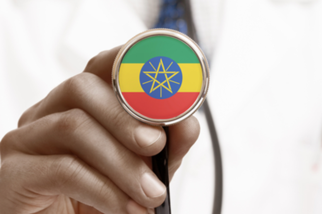 A male doctor holds a stethoscope up to the camera. The tip of the stethoscope is covered in the colours of the Ethiopian flag