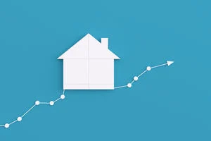 Graphic of a house made out of paper sitting on a financial bar chart.