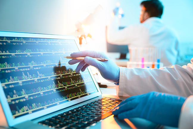Laboratory where a technician is operating a touch screen laptop with DNA graphs