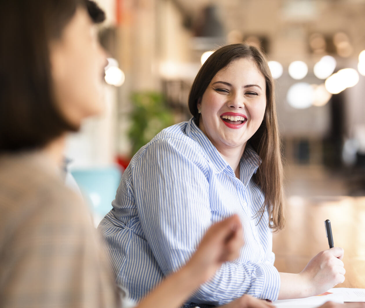 Two ladies at desk, happy