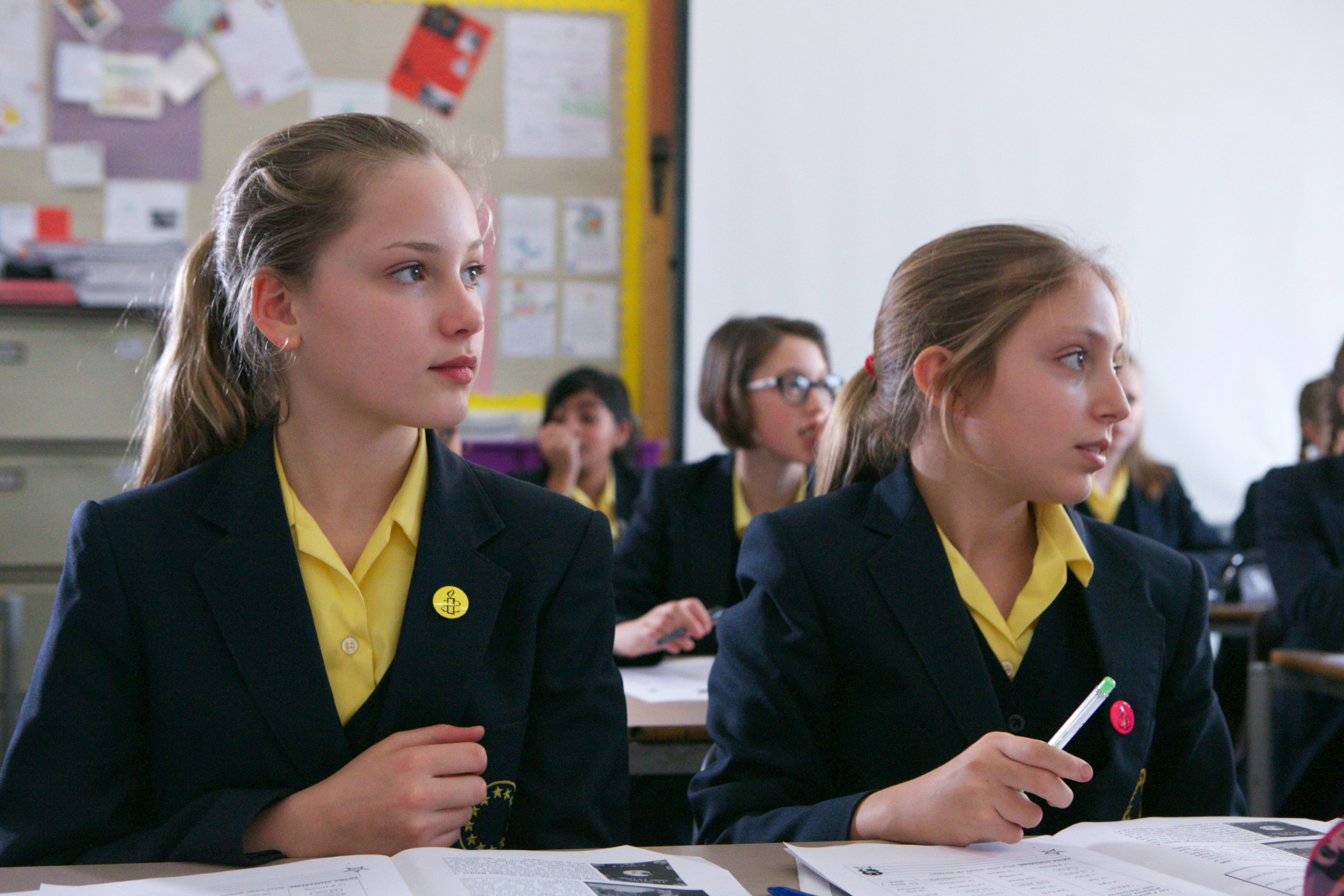 Girls listening to teacher in classroom