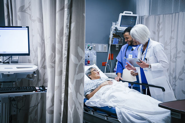 A nurse searching through paper patient files.
