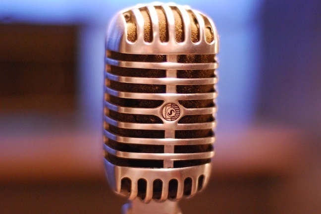 A silver 50s microphone against a blurred blue background.