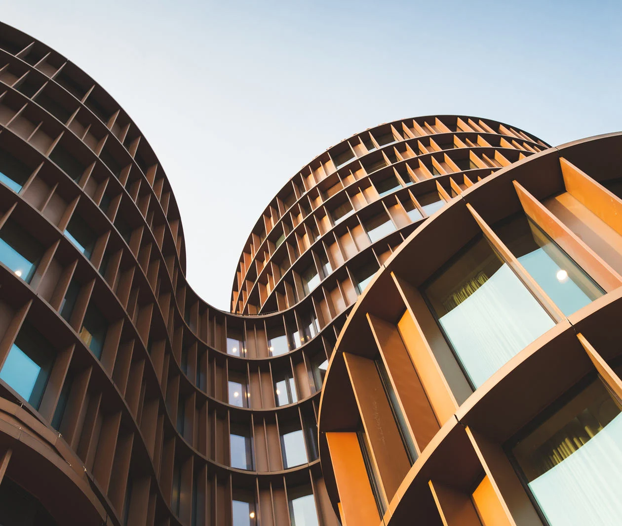 Image of large architectural building in metal and glass with curved features 