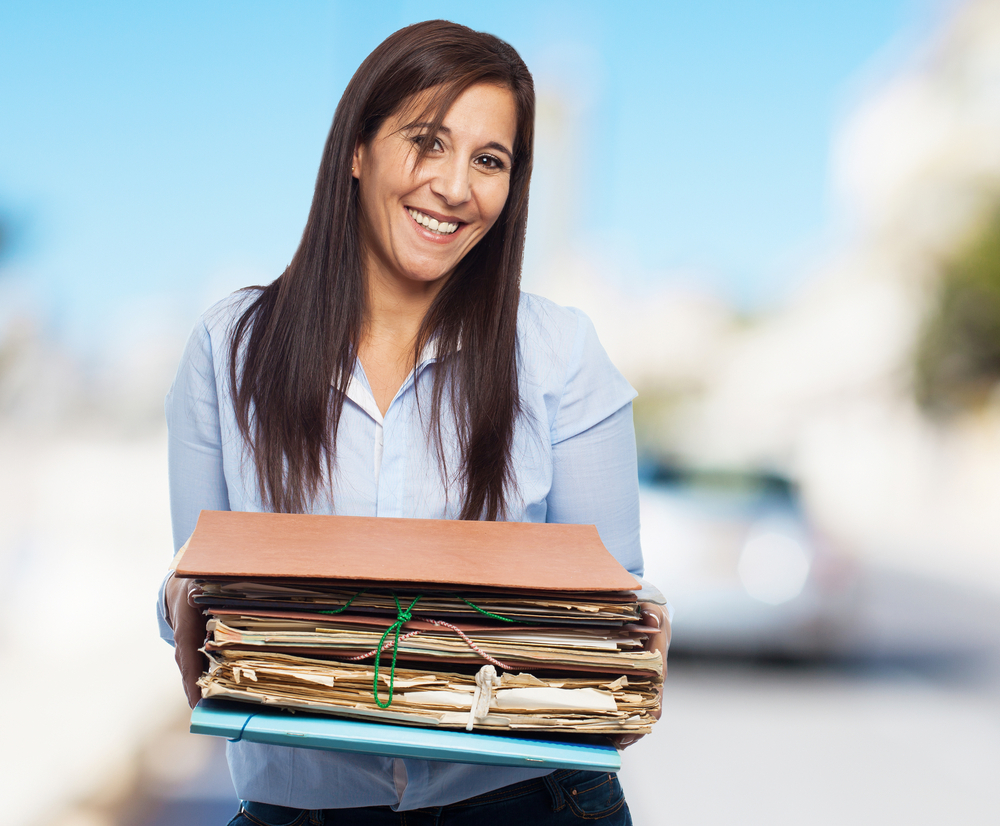 Women holding a large stack of research papers