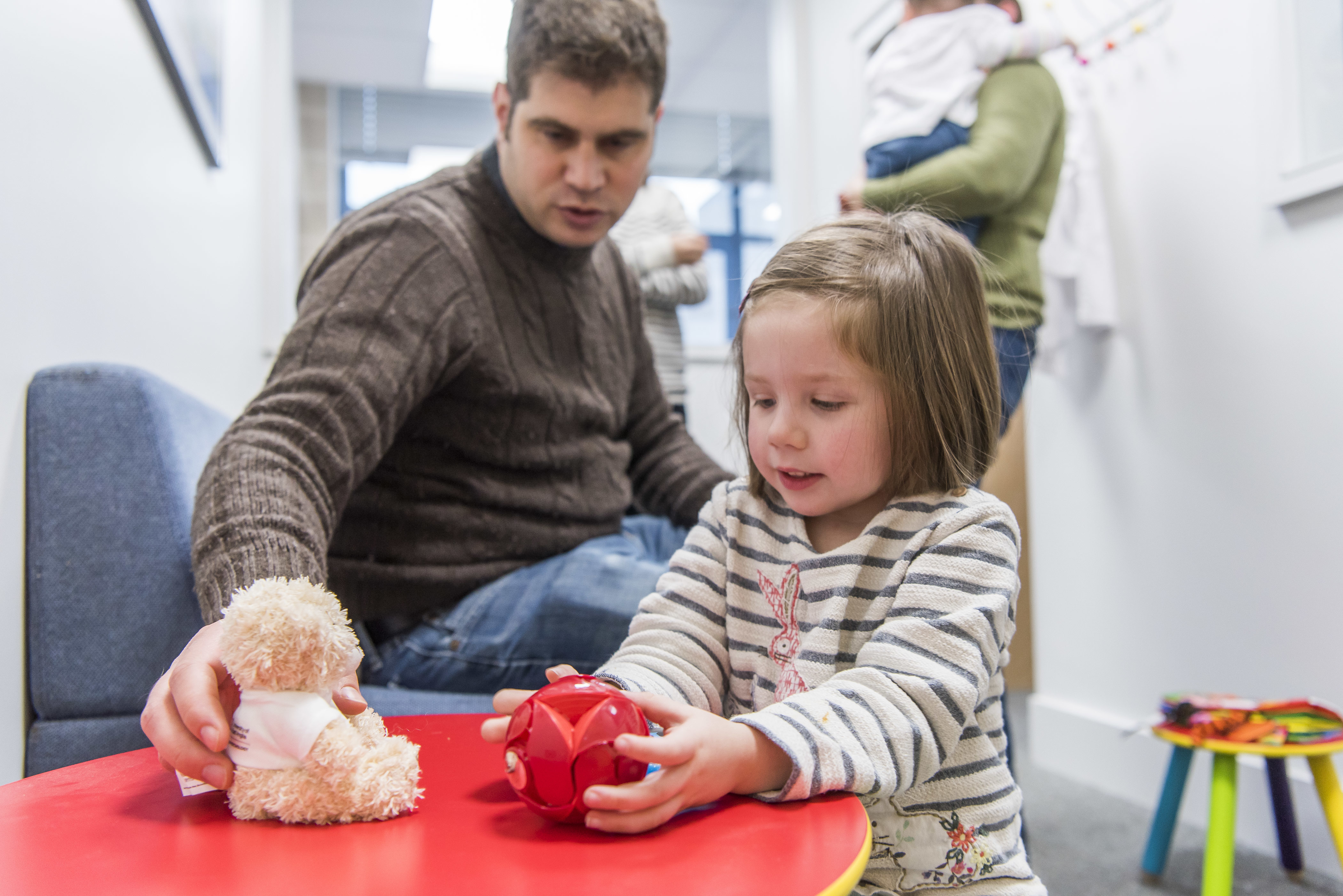 A child and her father playing a game