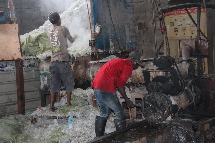 Two workers in a plastic recycling factory.