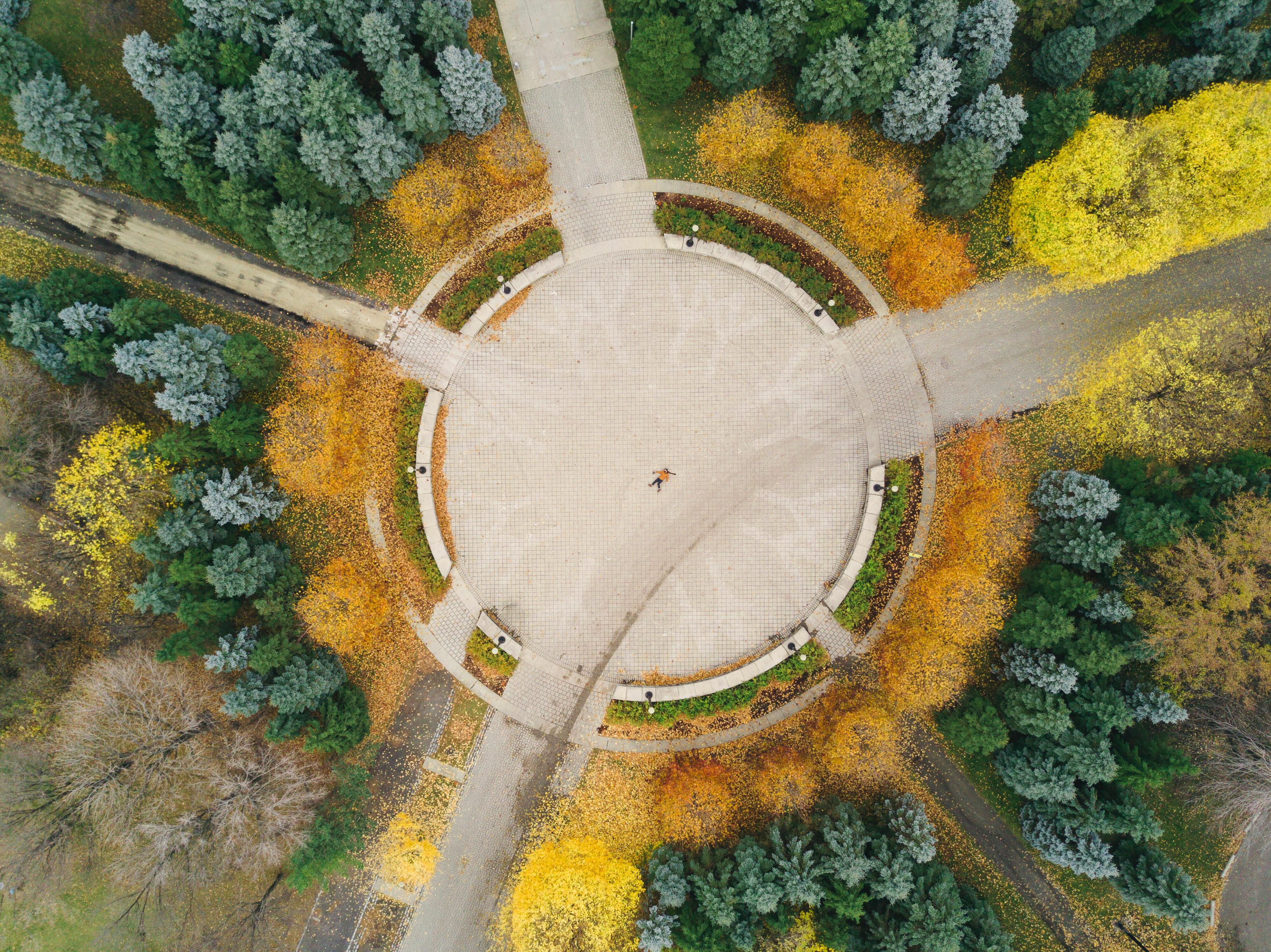 birds-eye view of  an empty road roundabout surrounded by trees