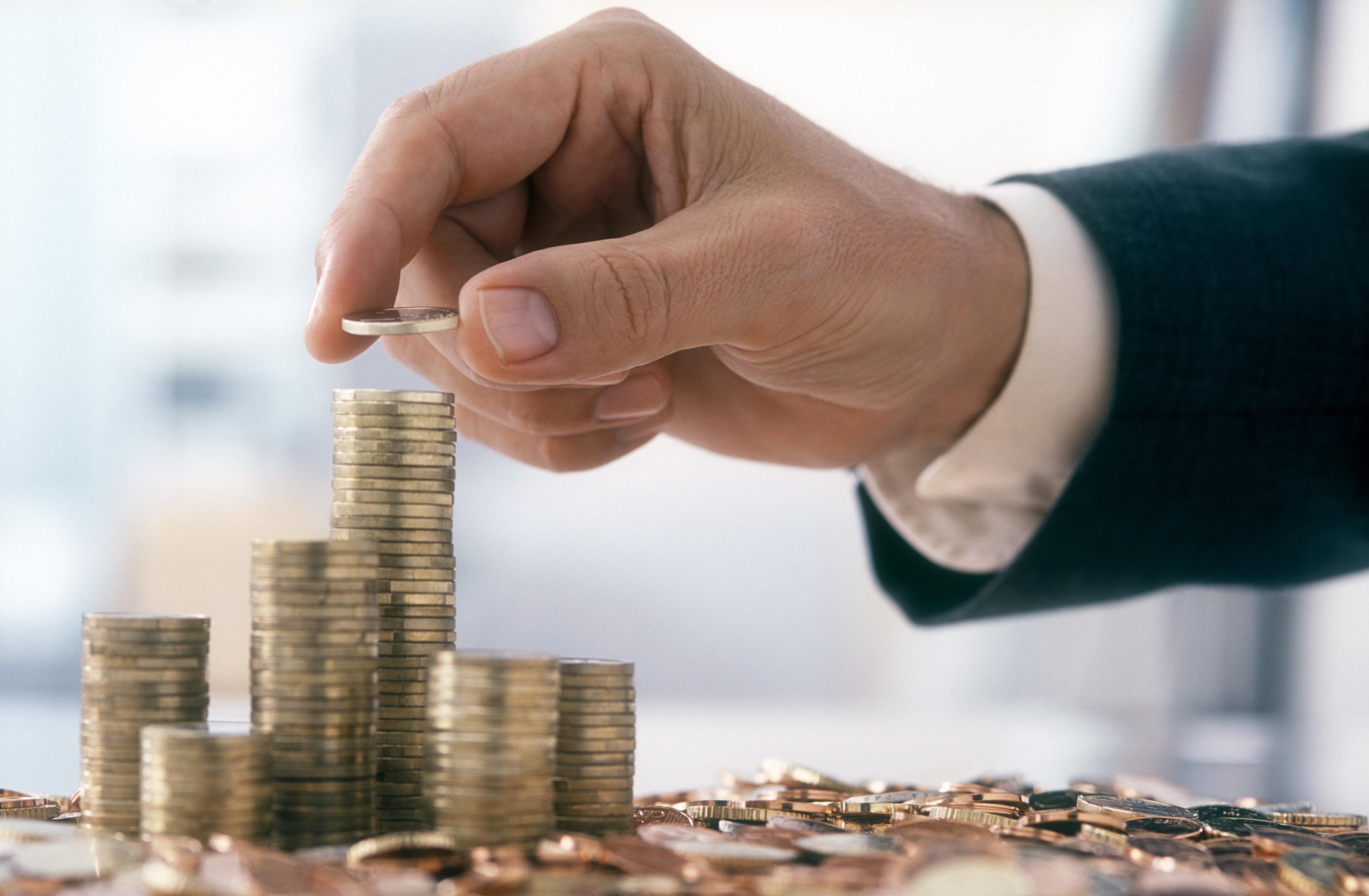 Business person stacking coins.