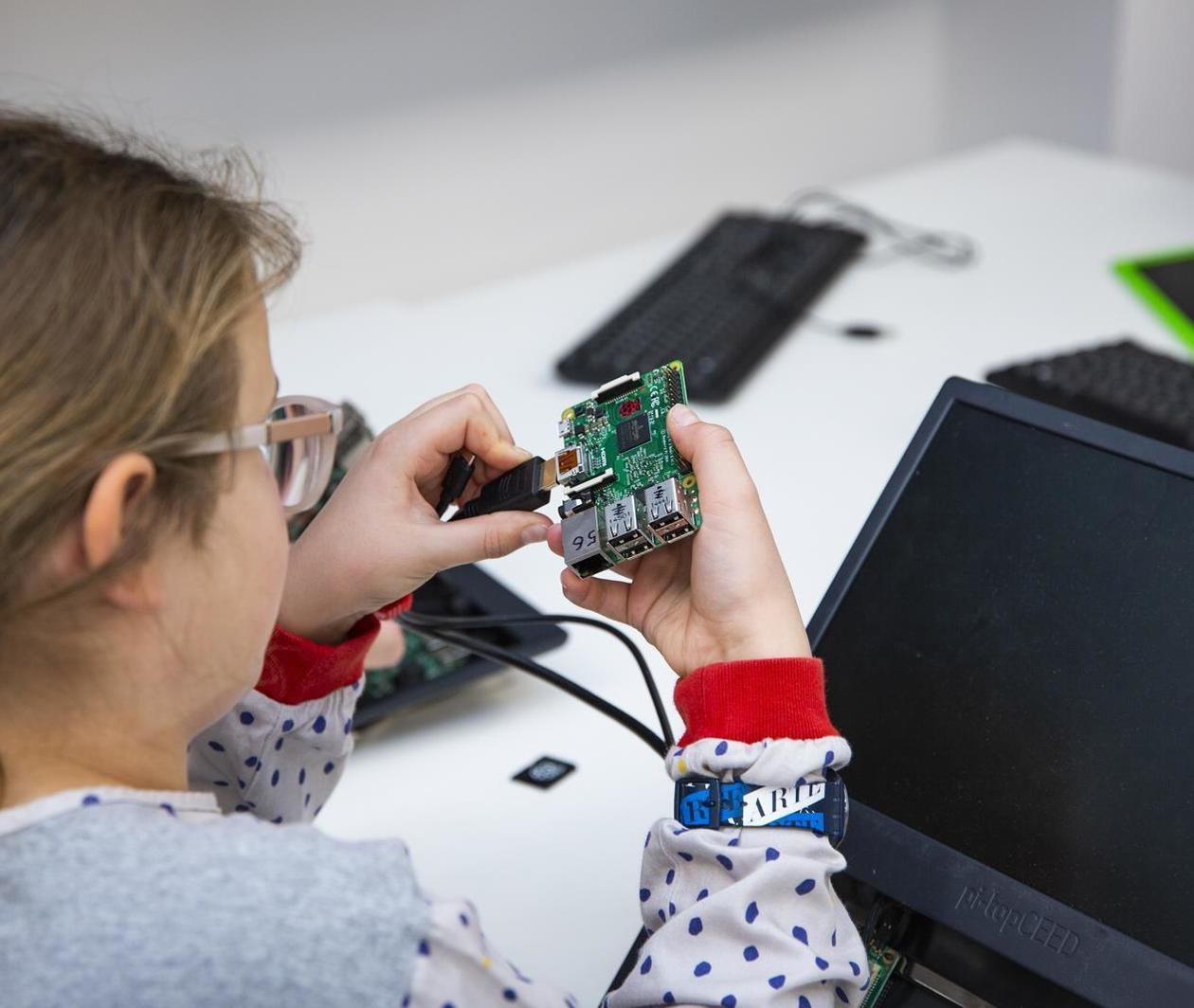 A girl plugging a HDMI cable into a Raspberry Pi