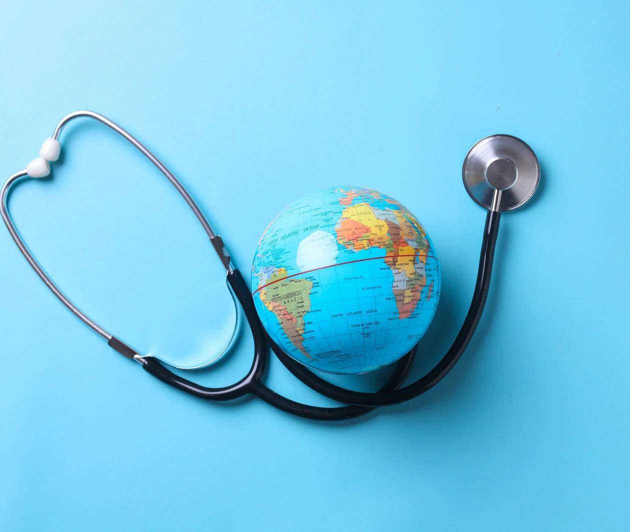 Globe with stethoscope isolated on blue background. Save the wold, Global healthcare and Green Earth day concept.