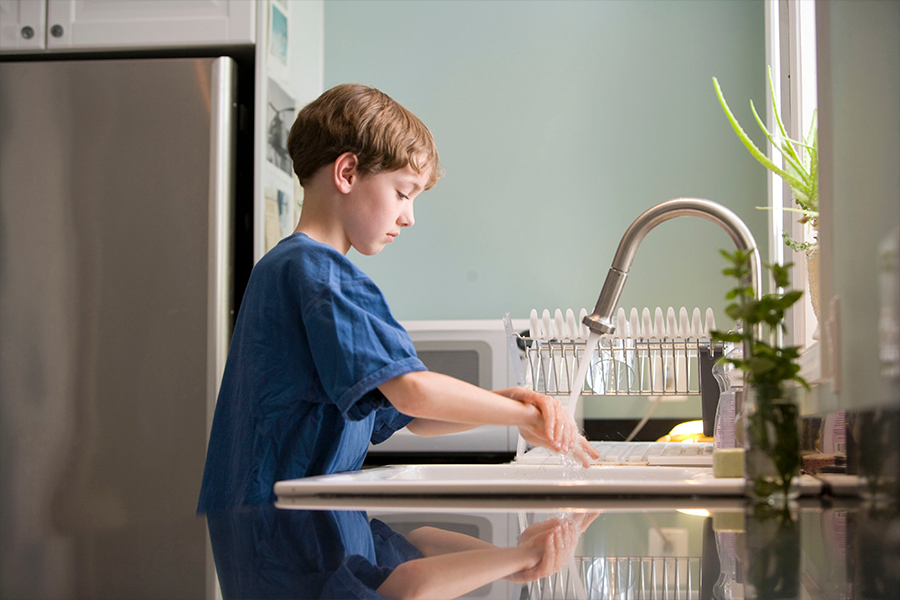 A young boy washing his hands