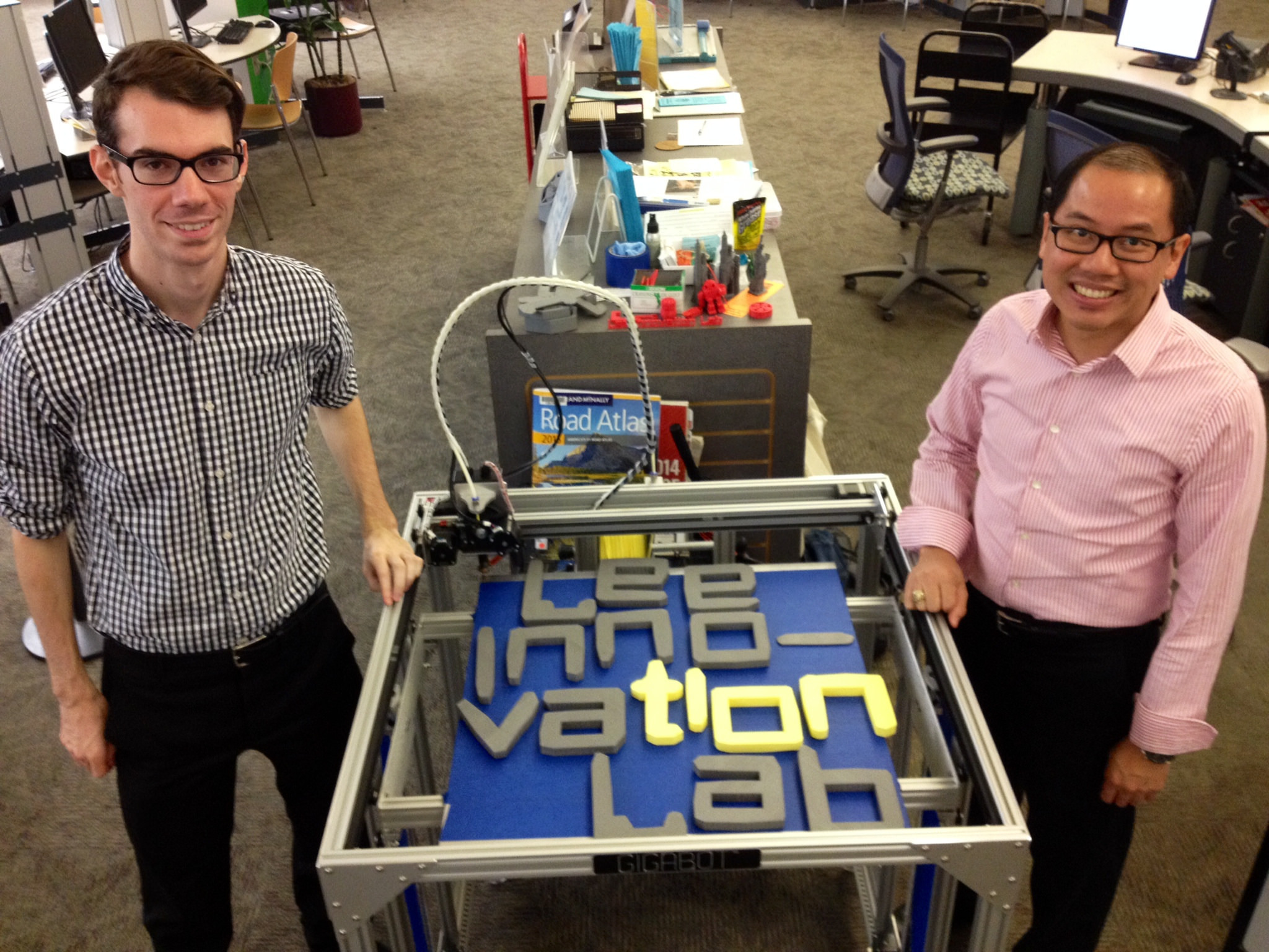 Two men standing by a maker project