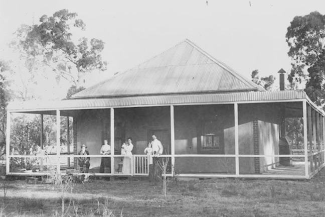 Historical photo of family standing on their front porch