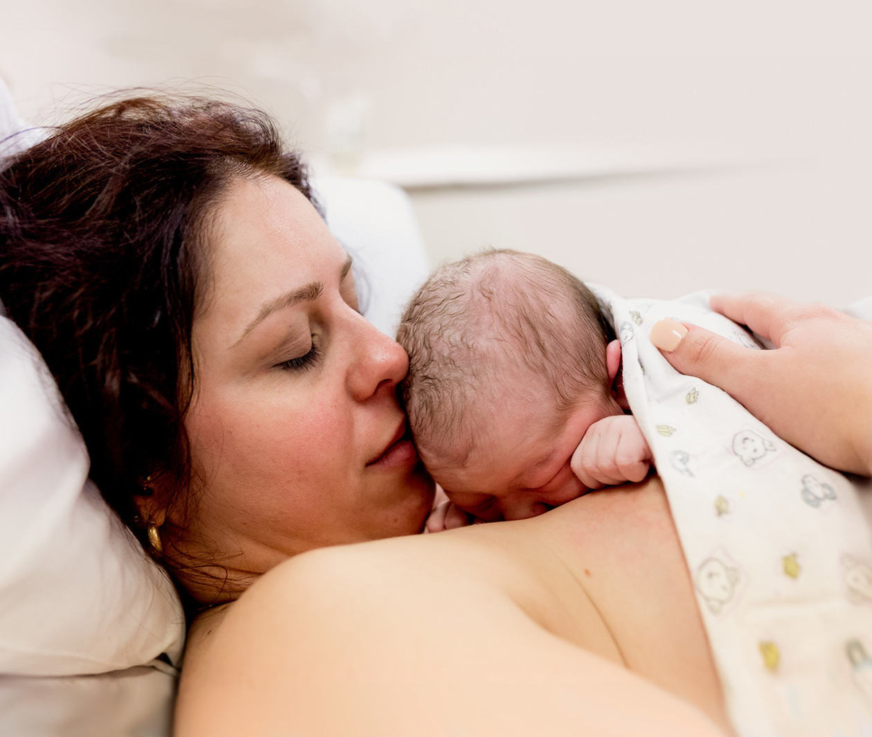 Blissful mother and baby cuddling immediately after birth. Copyright Brisbane Birth Photography.