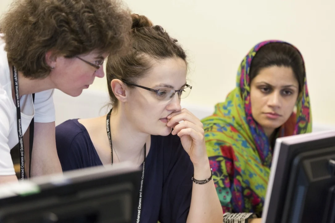 Group of learners looking at a computer screen, trying to figure out something together