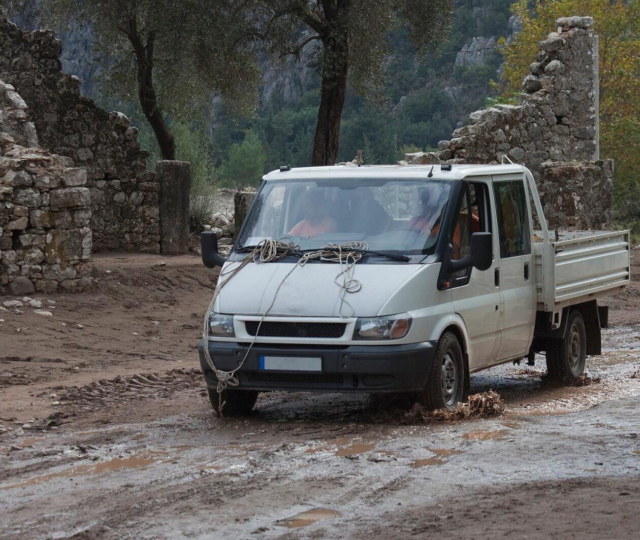 Pick up truck driving through muddy terrain.