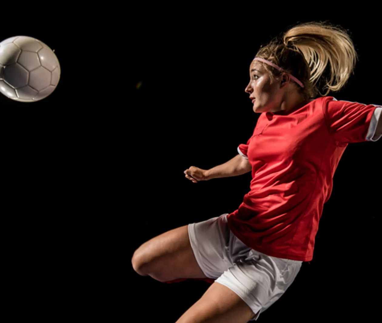 Female soccer player flying kick 