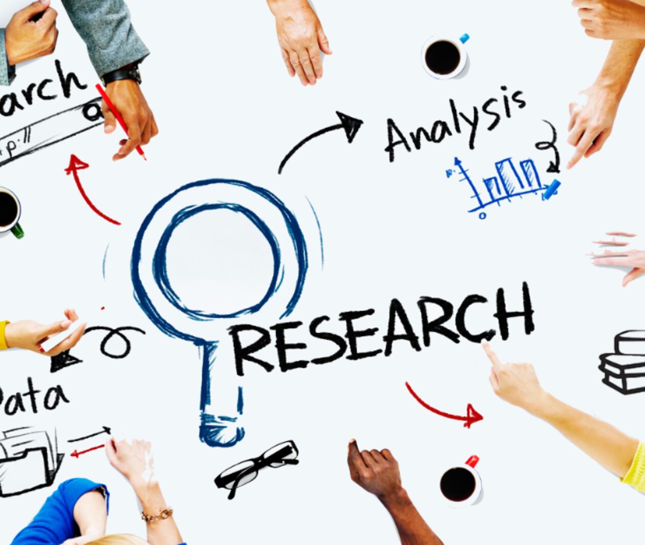 Table with Research and drawing of a magnifying glass on with different people pointing at different aspects