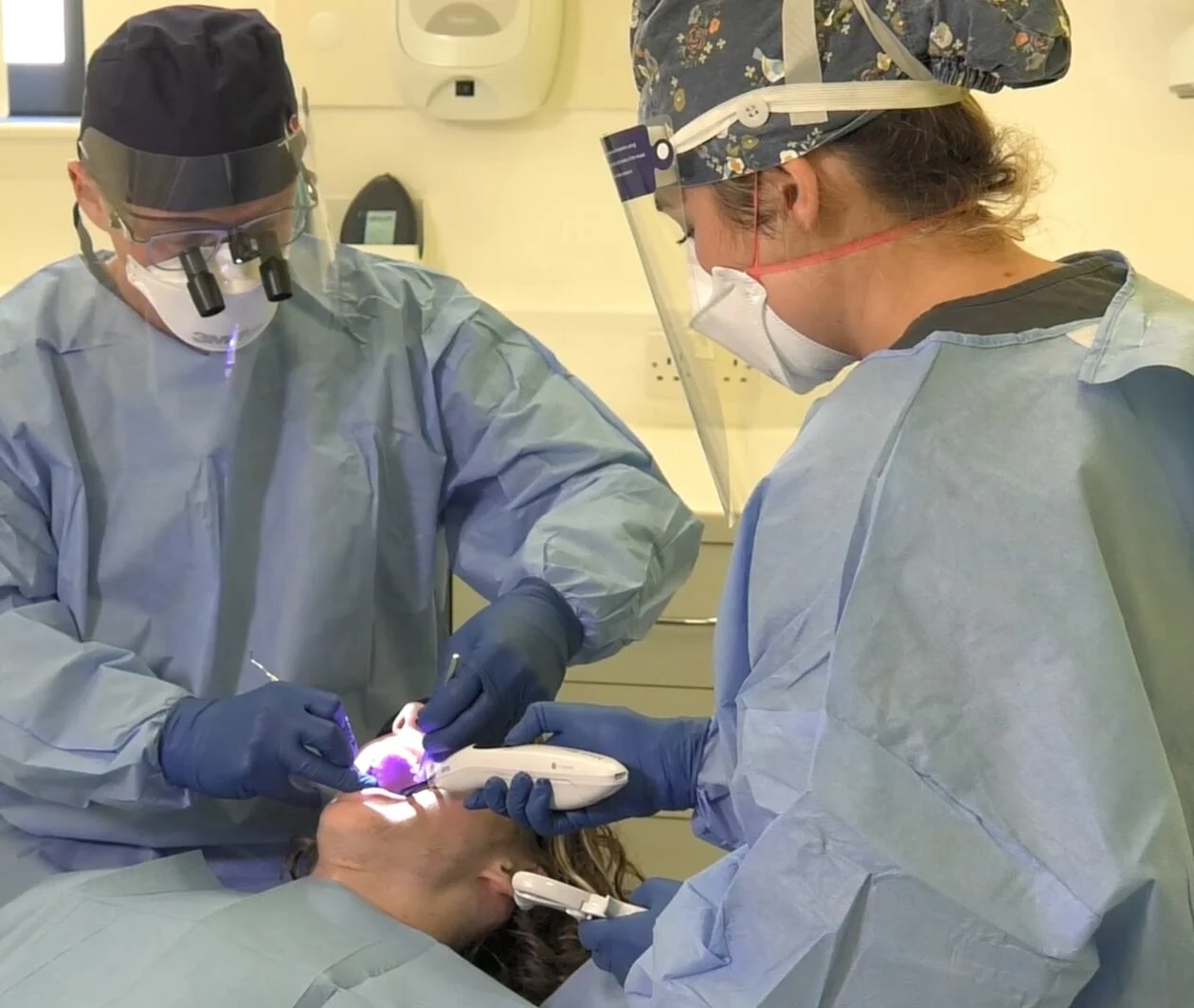 A dentist and vocational trainee providing treatment for a patient