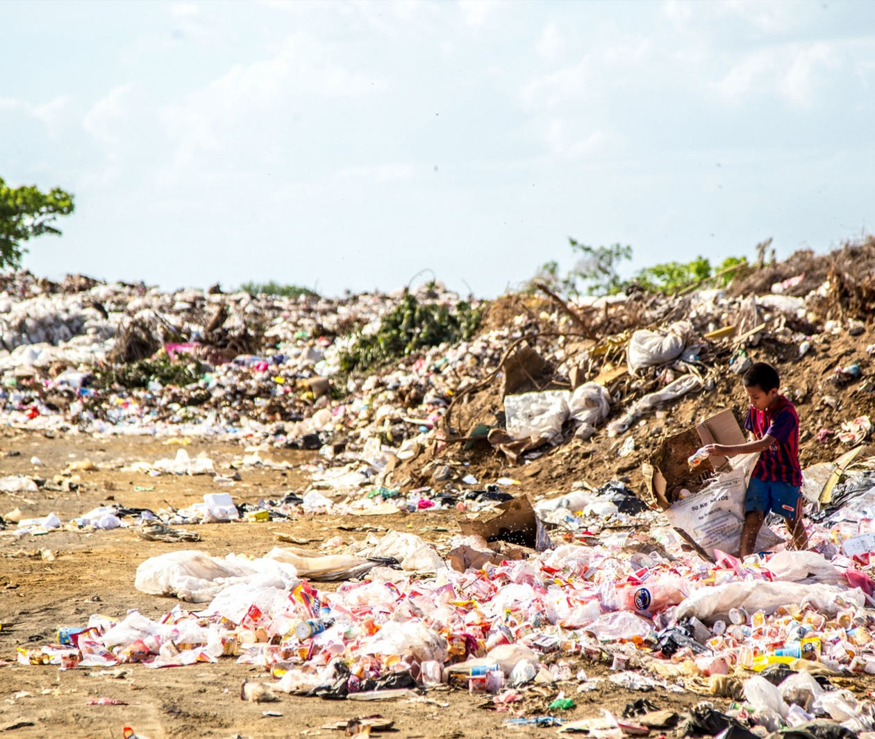 Image of a young boy looking for something to upcycle from a pile of rubbish