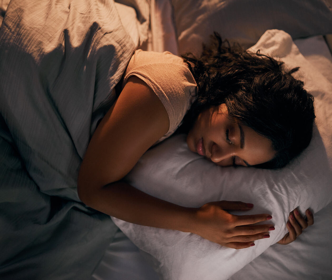 High angle shot of a beautiful young woman sleeping in her bed at home during the night