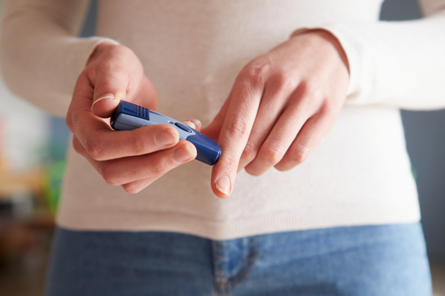 A woman holding a diabetes blood testing kit.