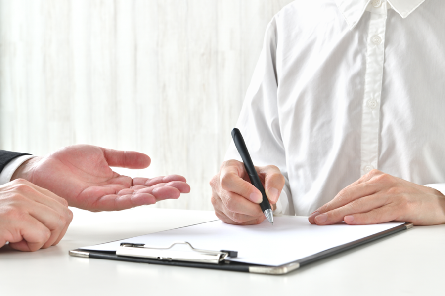 Business person signing contract and business man's hand. Contract/pre-contract agreement. Solicitor's desk.