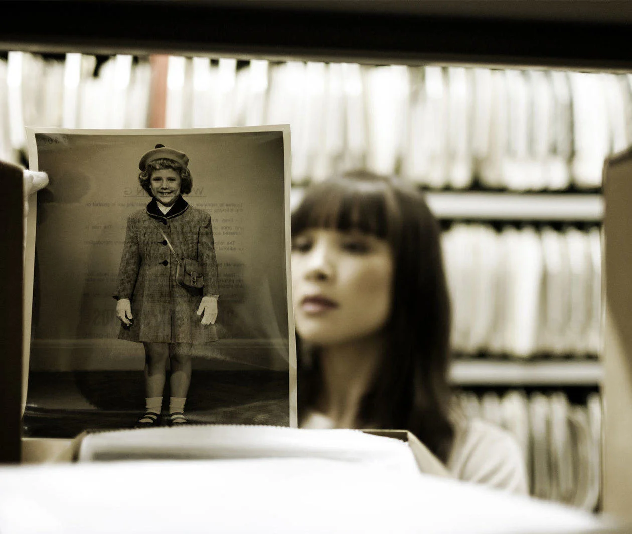 A researcher in an archive exploring photographs and other documentary sources