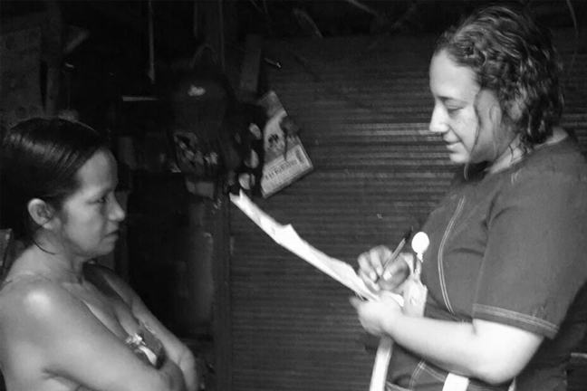 A woman asking another woman a question in a survey.