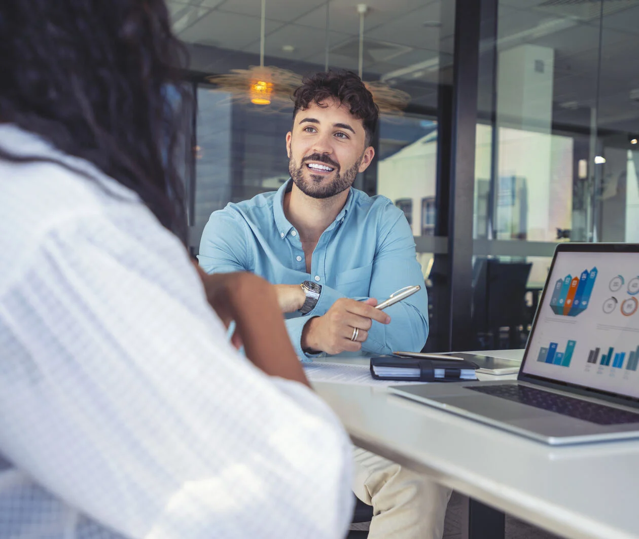 A man and a woman at a desk in an office analysing data. 