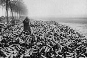 Man standing in a field of artillery shell casings during World War 1