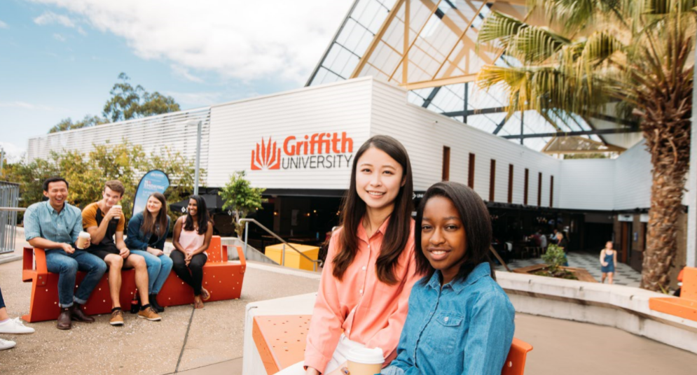 International students sitting in front of University building