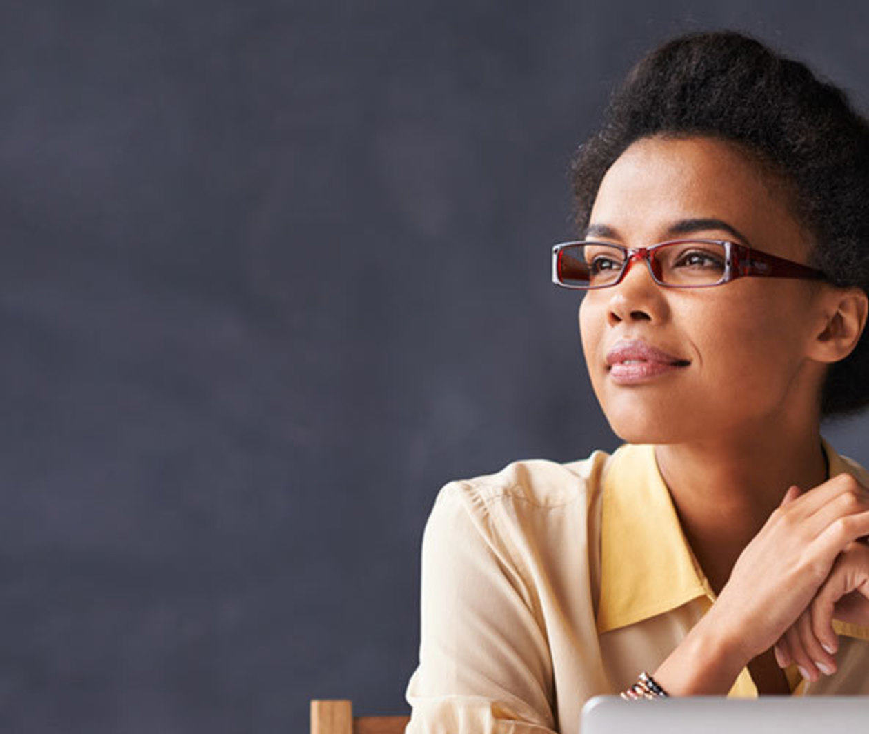 Woman sitting at work desk contemplating