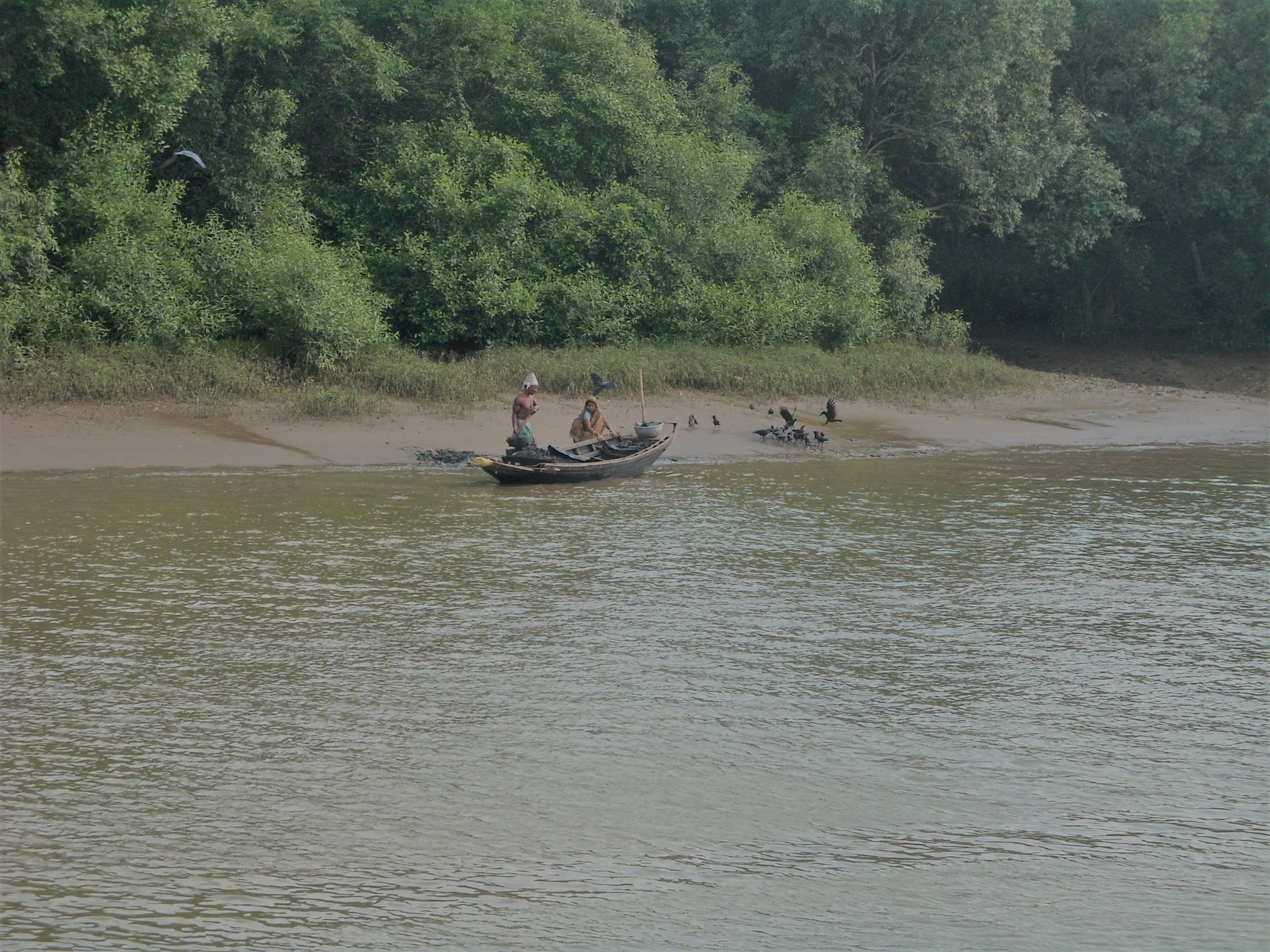 Two men with small boat the side of a river