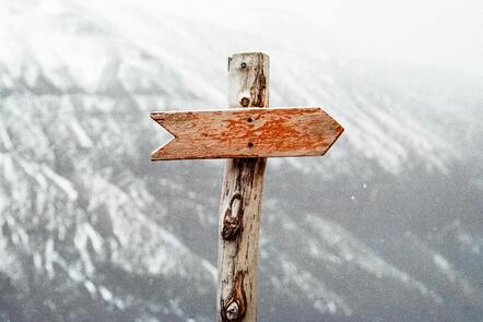 a wooden sign sitting on top of a wooden pole, Steering direction