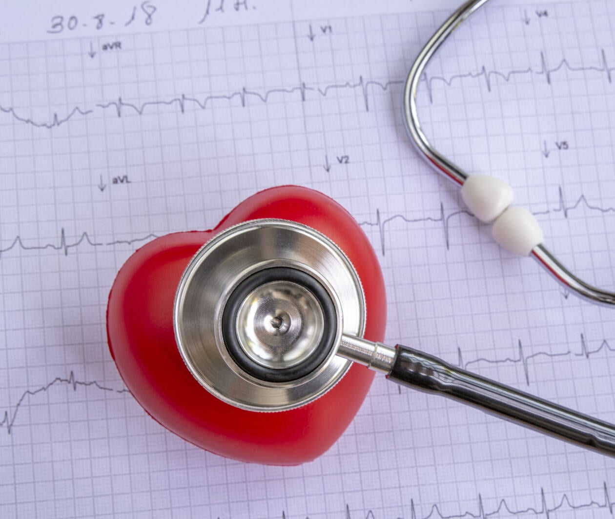 Medical stethoscope and red heart with cardiogram