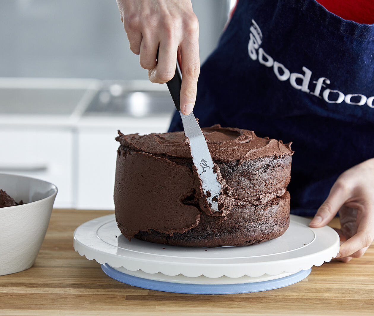 Putting icing on a chocolate cake