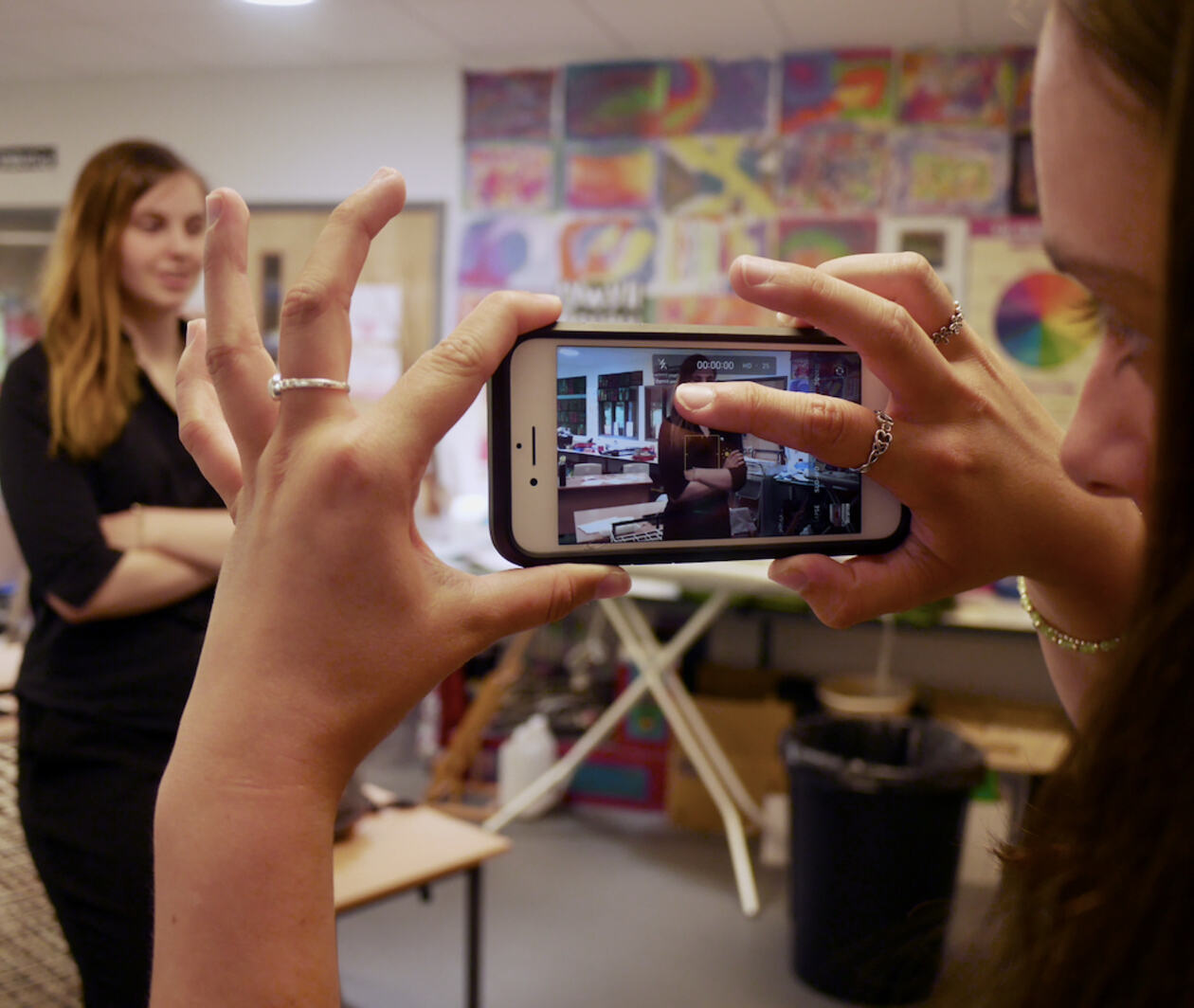 Woman operating a phone filming her friend 