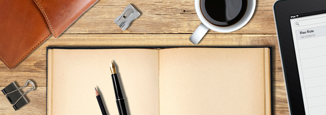 The course image for Start Writing Fiction. A pen and pencil sit on an open notebook with a coffee and an iPad close at hand, ready to start writing.