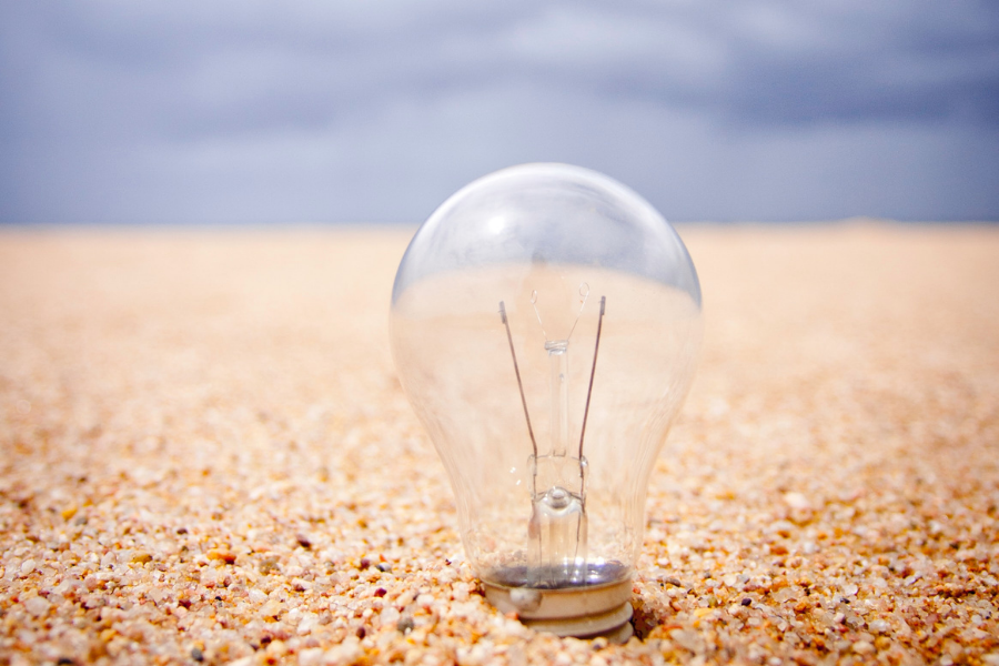 photo of a lightbulb in the sand