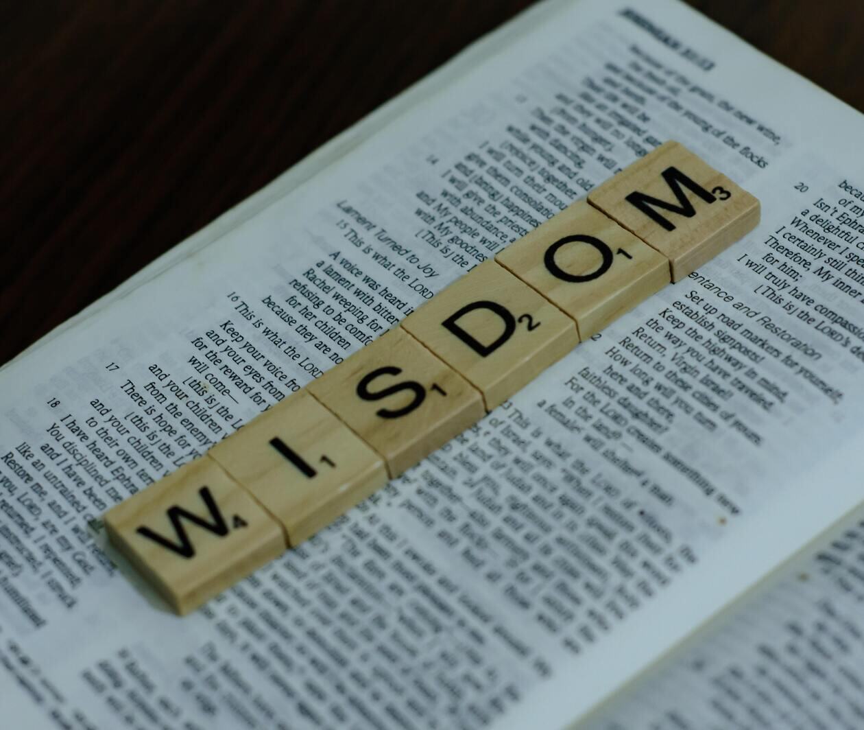 WISDOM spelled out in lettered tiles on a newspaper alex-shute-unsplash