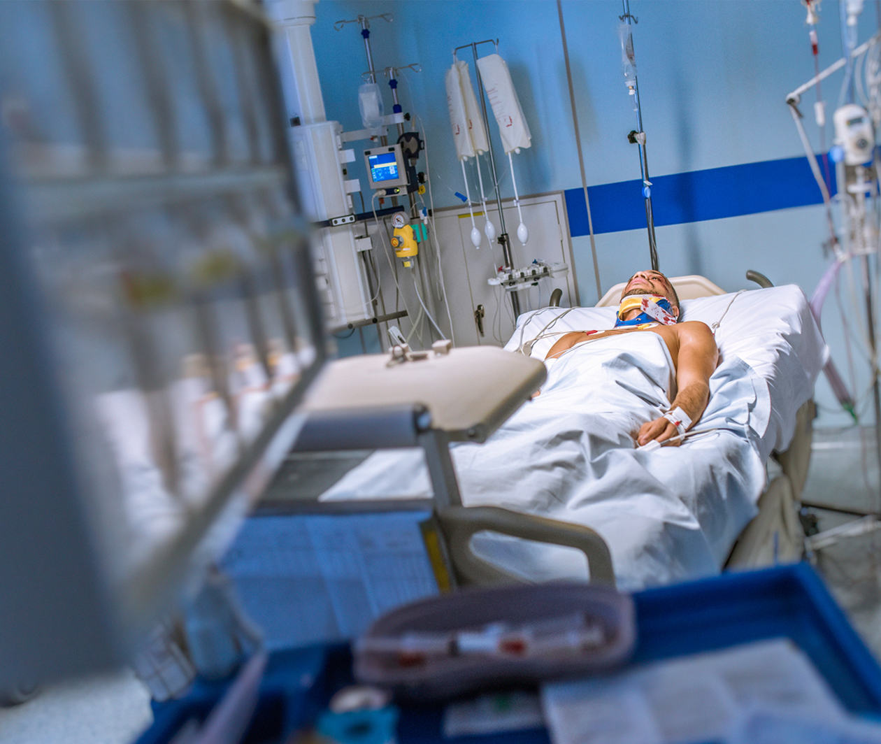 A patient in a hospital bed, connected to various machines