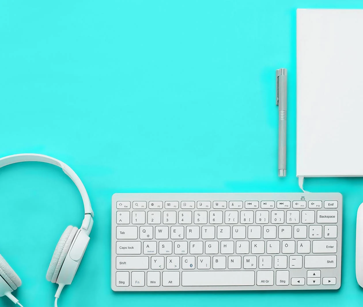 equipment needed to teach online. Keyboard, notebook, pen, headphones, mouse.