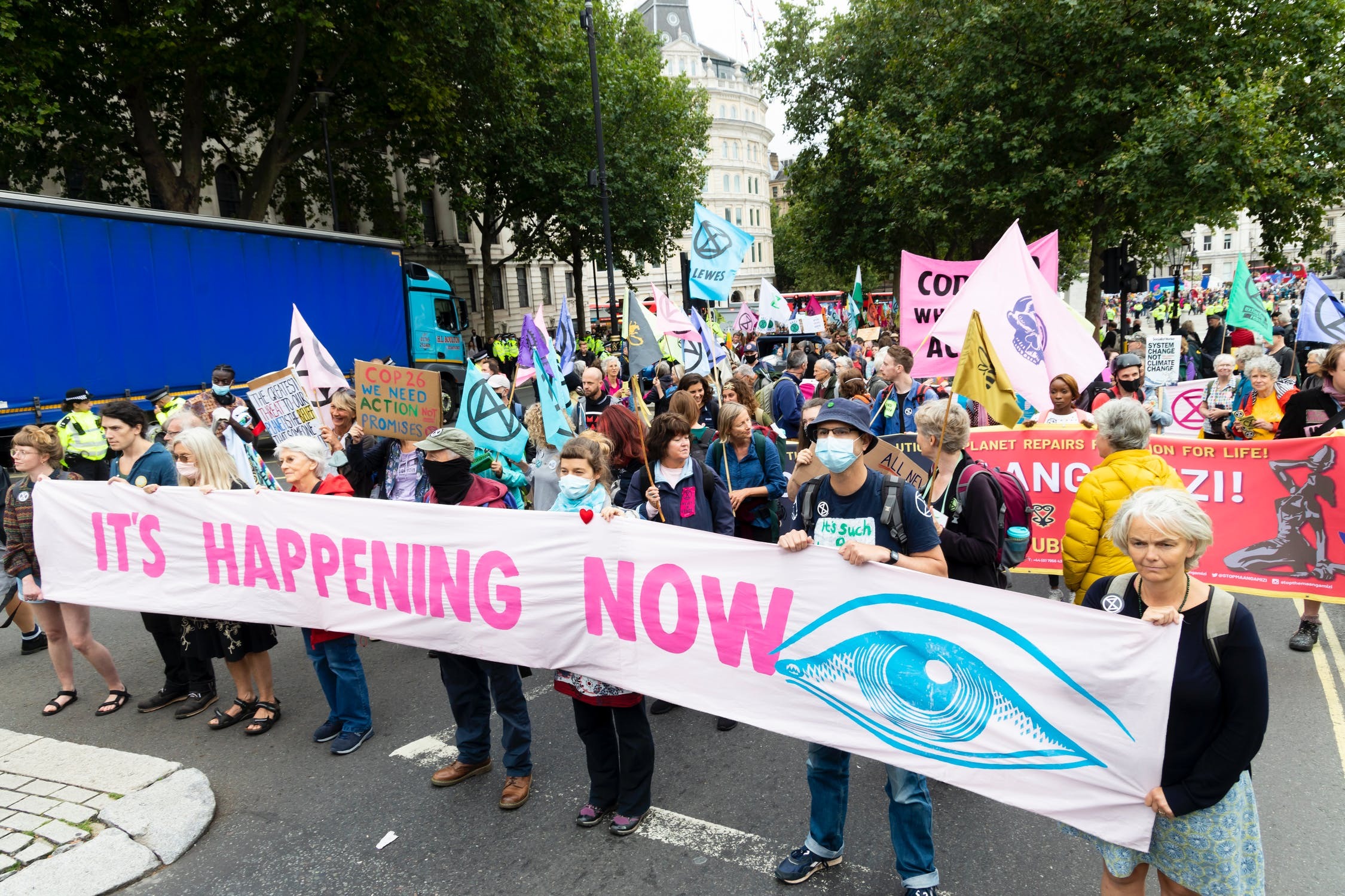 Climate protest group in the street wearing masks and carrying placards