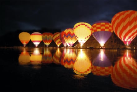 hot air balloons reflected on the surface of some water